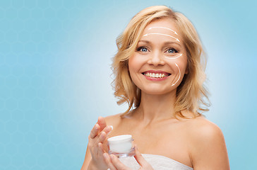 Image showing happy woman with cream jar