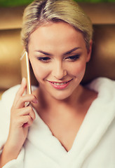 Image showing beautiful young woman with smartphone at spa