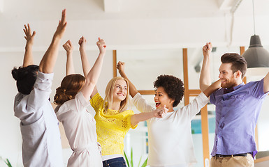 Image showing happy creative team celebrating victory in office