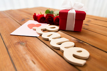 Image showing close up of gift box, red roses and greeting card