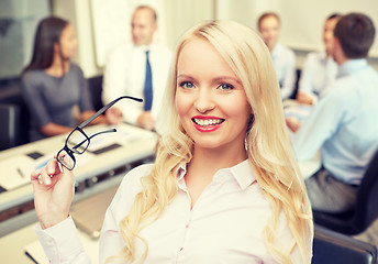 Image showing smiling businesswoman or secretary in office