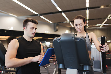 Image showing woman with trainer exercising on stepper in gym