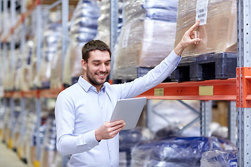 Image showing happy businessman with tablet pc at warehouse