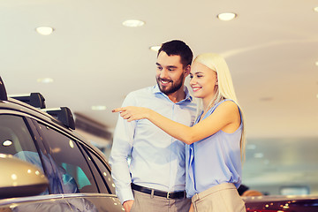 Image showing happy couple buying car in auto show or salon