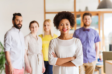 Image showing happy young woman over creative team in office