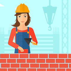 Image showing Bricklayer with spatula and brick.