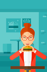 Image showing Woman eating hamburger. 