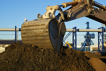 Image showing Hydraulic excavator at work. Shovel bucket against blue sky