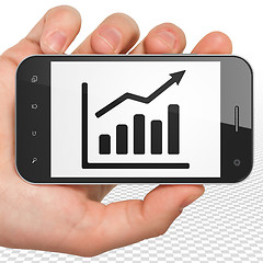 Image showing News concept: Hand Holding Smartphone with Growth Graph on display