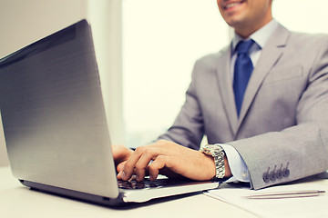 Image showing close up of businessman with laptop and papers