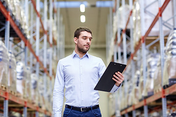 Image showing businessman with clipboard at warehouse