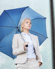 Image showing young serious businesswoman with umbrella outdoors