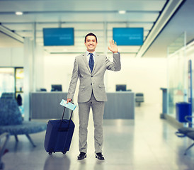 Image showing happy businessman in suit with travel bag