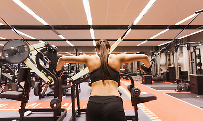 Image showing woman flexing muscles on cable machine in gym