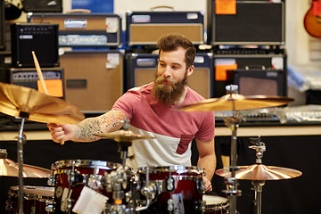 Image showing male musician playing cymbals at music store