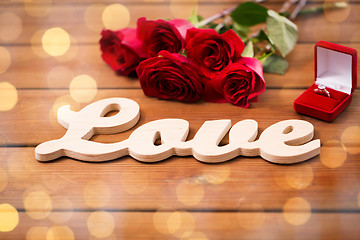 Image showing close up of diamond ring, red roses and word love