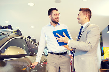 Image showing happy man with car dealer in auto show or salon