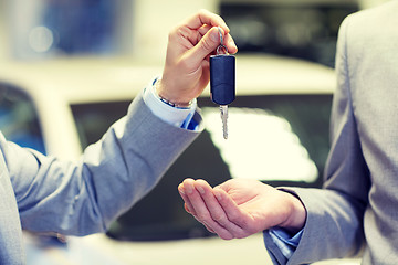 Image showing close up of male hands with car key in auto salon