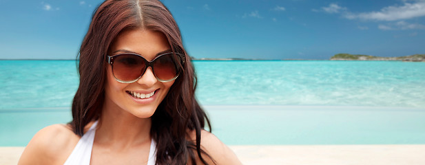 Image showing smiling young woman with sunglasses on beach