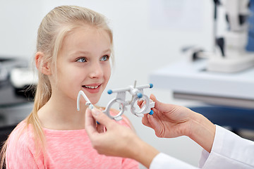 Image showing optician with trial frame and girl at clinic