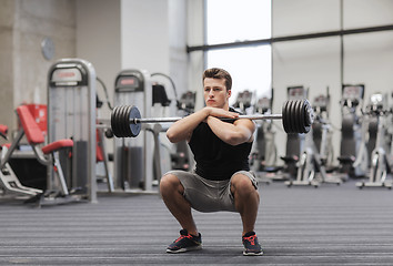 Image showing young man flexing muscles with barbell in gym