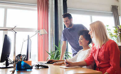 Image showing happy creative team with computer in office