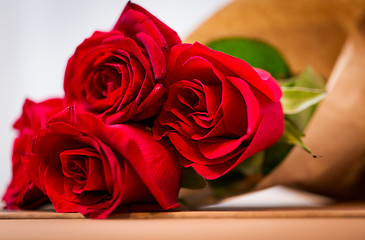 Image showing close up of red roses bunch wrapped into paper