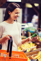 Image showing happy young woman with food basket in market