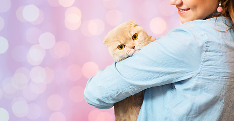 Image showing woman holding scottish fold cat over pink lights