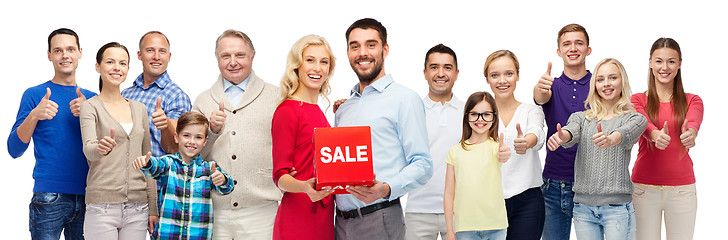 Image showing happy people with red sale sign showing thumbs up