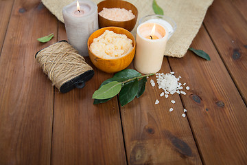 Image showing close up of natural body scrub and candles on wood