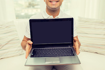 Image showing close up of happy man showing laptop at home