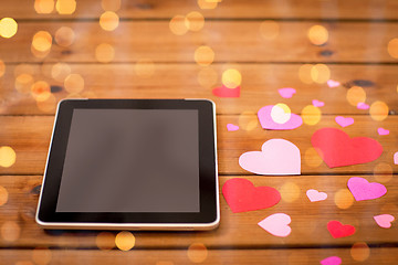 Image showing close up of tablet pc and hearts on wood