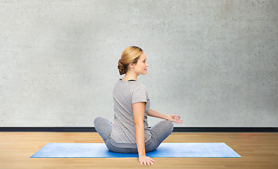 Image showing woman making yoga in twist pose on mat