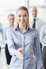 Image showing smiling businesswoman making handshake in office