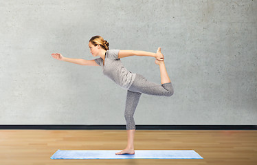 Image showing woman making yoga in lord of the dance pose on mat