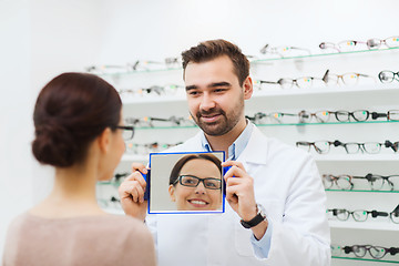 Image showing woman in glasses looking to mirror at optics store