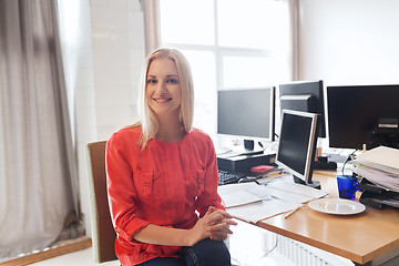 Image showing happy creative female office worker with computers