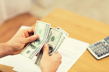 Image showing close up of man hands counting money at home