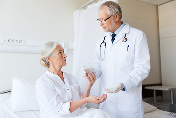 Image showing doctor giving medicine to senior woman at hospital