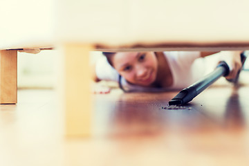 Image showing close up of woman with vacuum cleaner at home