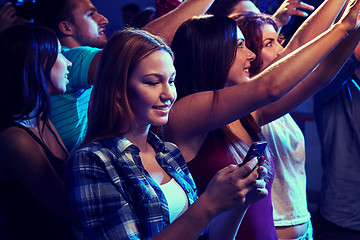 Image showing woman with smartphone texting message at concert