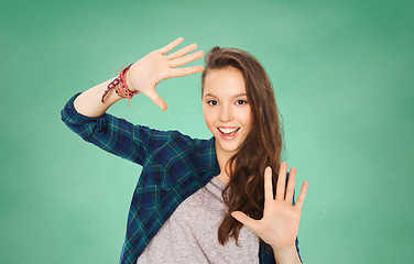 Image showing happy smiling student teenage girl showing hands