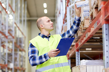 Image showing man with clipboard in safety vest at warehouse