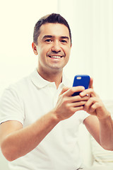 Image showing happy man with smartphone at home