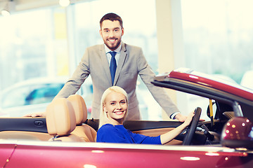 Image showing happy couple buying car in auto show or salon