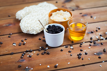 Image showing close up of coffee scrub in cup and honey on wood