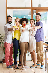 Image showing happy creative team showing thumbs up in office