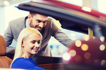 Image showing happy couple buying car in auto show or salon