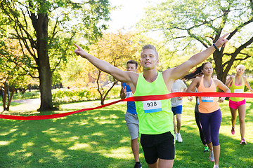 Image showing happy young male runner winning on race finish